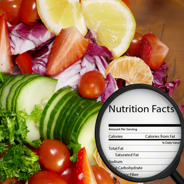 Close-up of a fresh salad with cucumbers, tomatoes, strawberries, and lemon slices, alongside a magnified nutrition facts label.